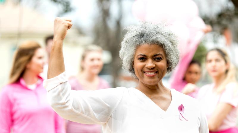 A woman flexes her muscle indicating strength.