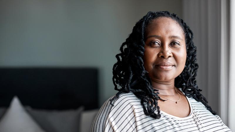 Portrait of a mature african american woman at home. She is looking at the camera with a serious expression.