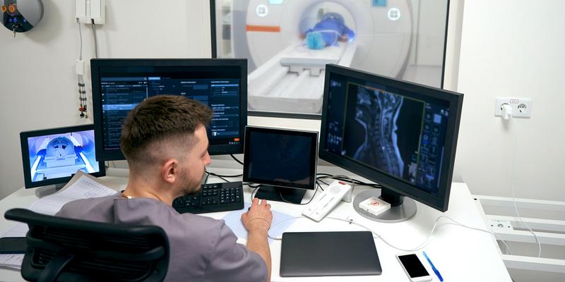 A diagnostic radiologist monitors while a patient undergoes diagnostic imaging scans.