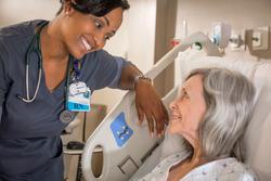 A nurse talks with a patient in a hospital bed at MedStar Health.