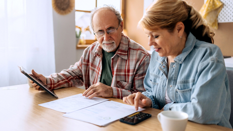 Two family members sit together and discuss finances at home.