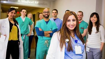 A group of cardiovascular disease fellows pose for a photo in a hospital hallway
