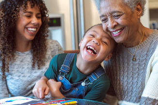 A young girl and her mother and grandmother laugh together. 