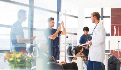 Cancer doctors and nurses provide chemotherapy for patients in an infusion center.