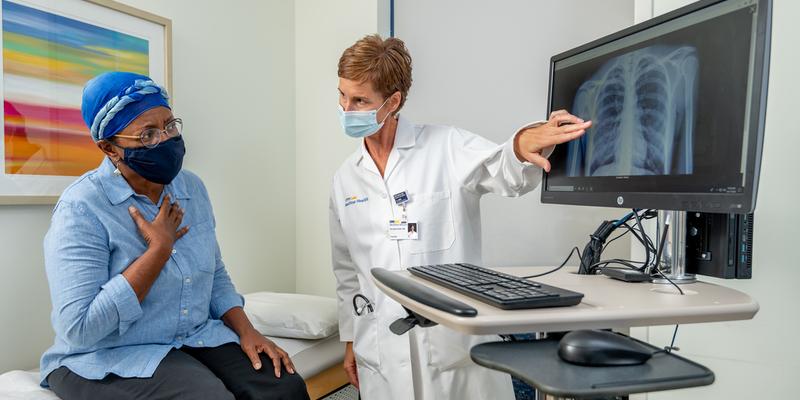 A female doctor consults with an african american female patient in a clinical setting.