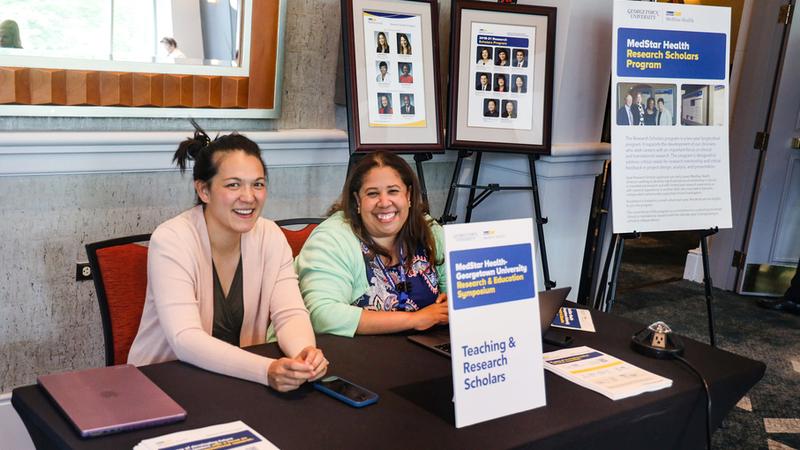 Team photo of MedStar Health's Teaching and Research Scholars exhibit table at a conference.