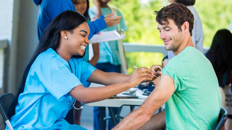 Man receives immunization from at vaccination clinic