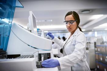 A young woman using a machine to conduct a medical test in a laboratory