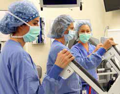 MedStar Health联合BSN、注册护士Kaylee Hartsfield和围手术期服务CSFA Donna Guy在使用达芬奇手术系统进行第一次手术前与Jennifer Harmon进行培训。