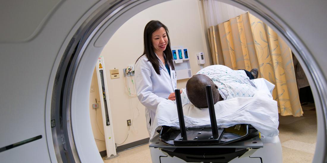 A doctor talks with a patient who is about to undergo diagnostic radiology.