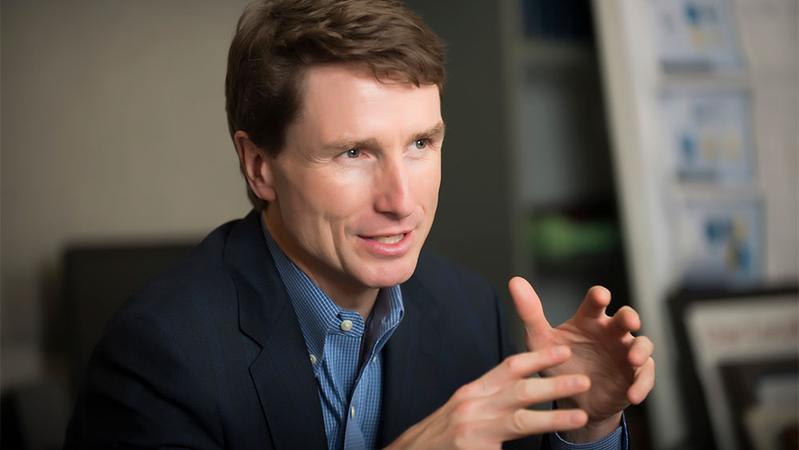 Environmental portrait of Dr James Higgins in an office setting.