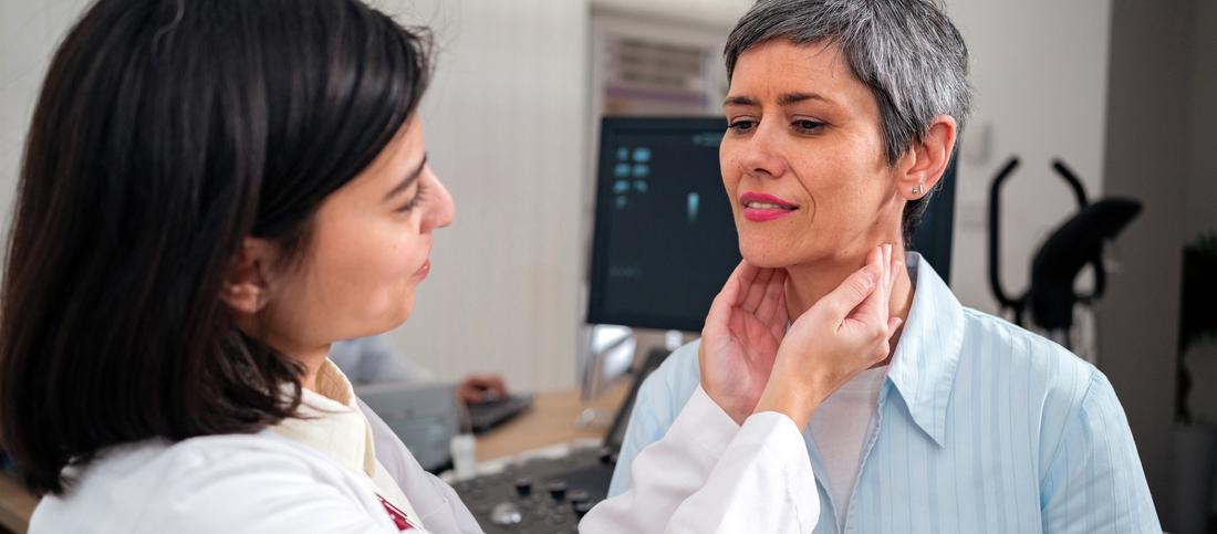 A doctor feels the glands of a patient during an examination.