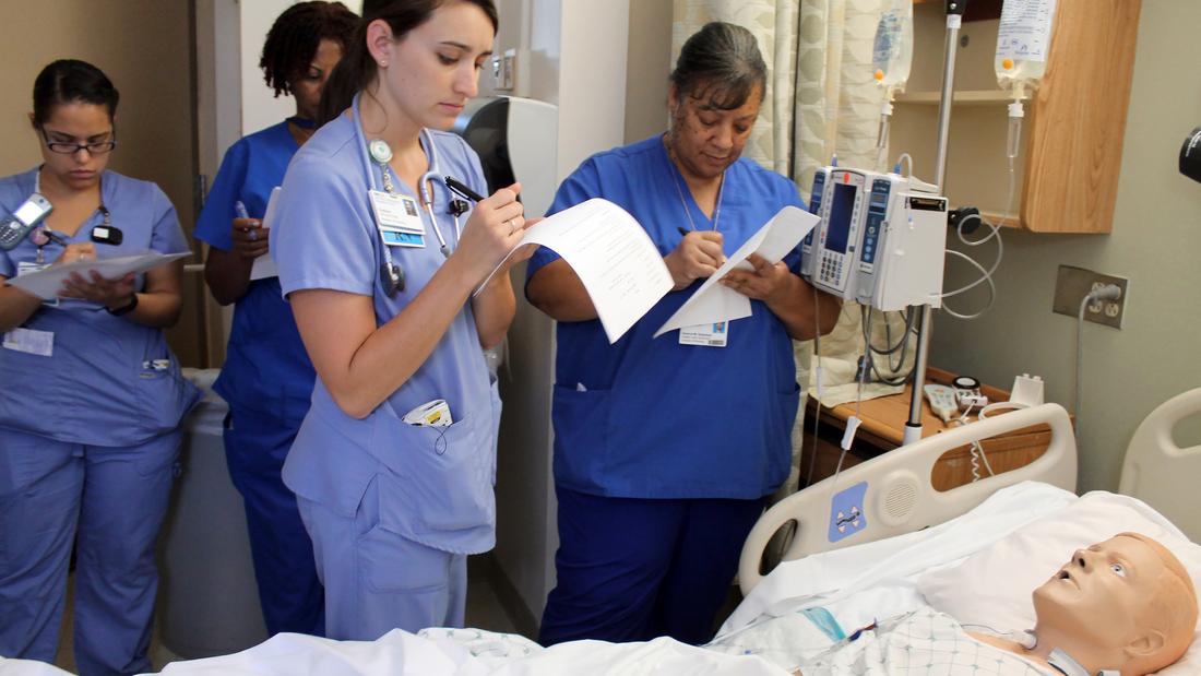 A group of nurses participates in simulation training.