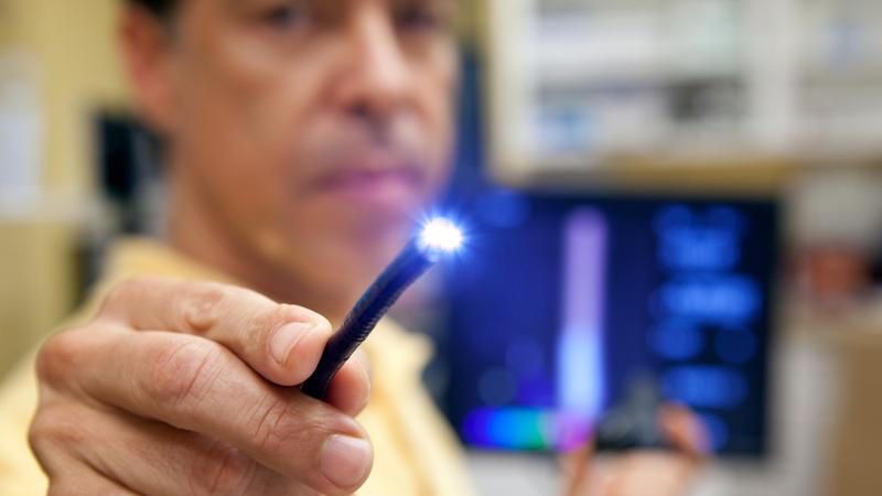 A doctor holds the lighted end of a probe used in endoscopic procedure.