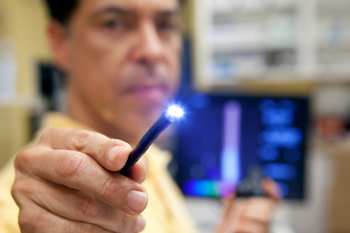A doctor holds the lighted end of a probe used in endoscopic procedure.
