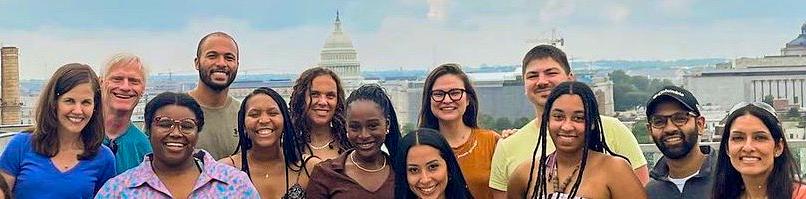 Students from MedStar Health's Family Medicine Residency Program in DC pose for a group portrait outdoors with the DC skyline in the background.