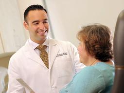 Dr. Gabriel Del Corral talks with a patient in a clinical setting.