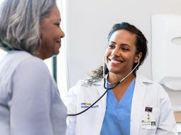 A doctor has a routine preventative exam with a patient and talks about acute care and disease management at an office visit.
