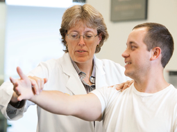 Dr Leigh Ann Curl works with a patient while a fellow MedStar Health sports medicine colleage looks on.