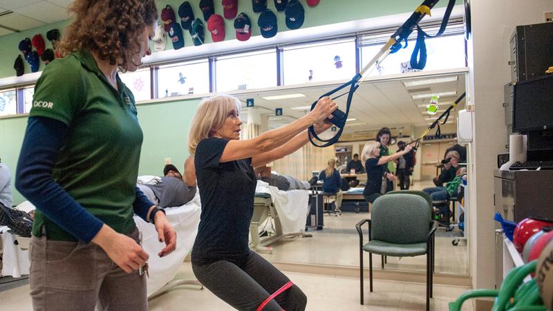 A MedStar Health physical therapy associate helps a patient develop upper body strength.
