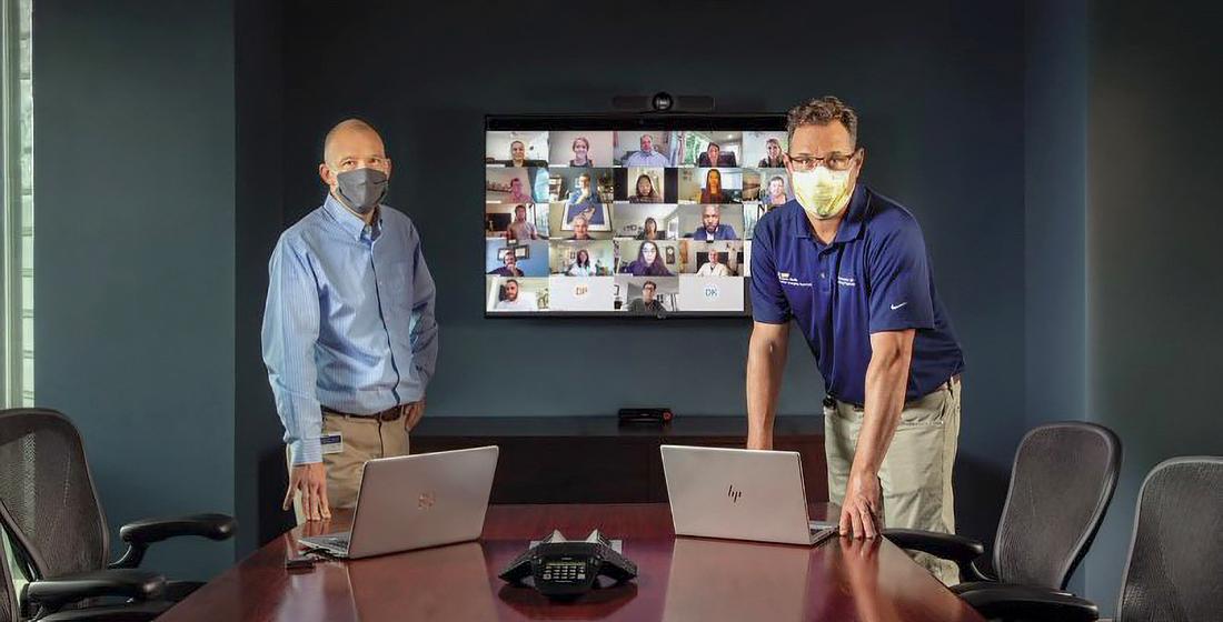 Two MedStar Health professionals wearing masks lead a telehealth meeting with a group of medical students.