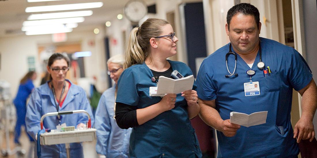 Two nurses talk together as the walk in a hospital hallway at MedStar Health.