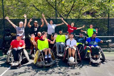 A group of athletes in MedStar Health's adaptive fitness program pose for a photo outdoors.