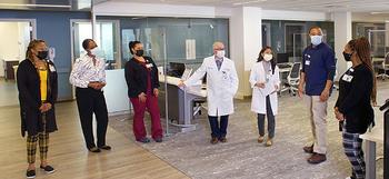 The staff of The Good Health Center stands together, socially distanced and wearing masks, in the lobby of the O'Neill Building on the campus of MedStar Good Samaritan Hospital.