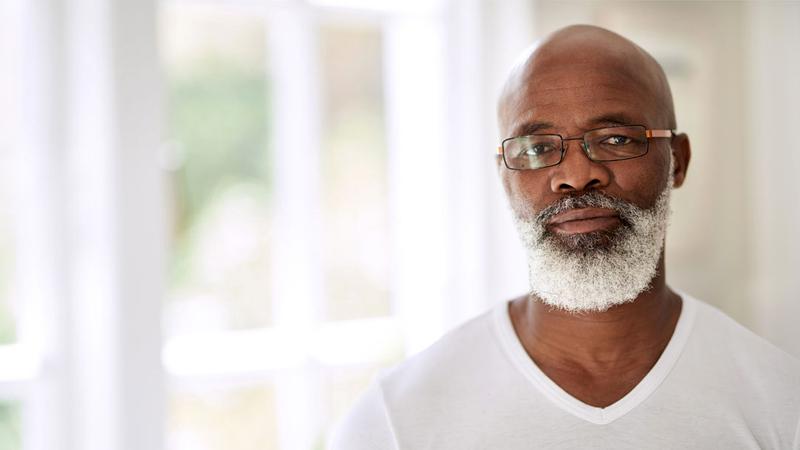 A mature african american man poses for a photo in a home setting