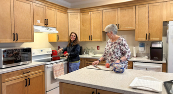 2 women cook in the kitchen at Hospice House of St. Mary's.