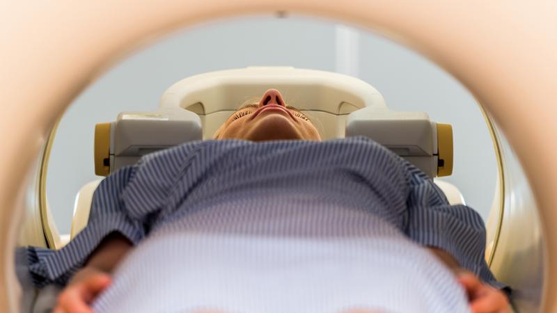 A woman lays in a diagnostic imaging machine to get a scan.