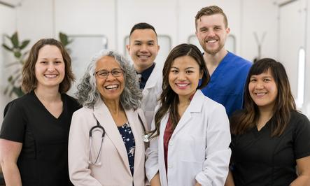 Healthcare workers pose for a photo in a medical office.