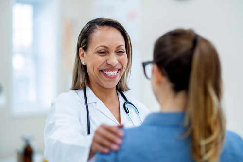 A nurse talks with a patient in a clinical setting.