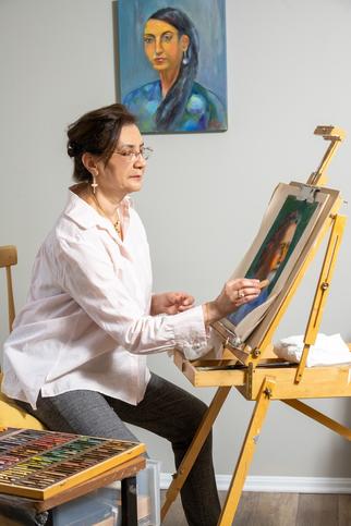 Nahed El Kassar paints a portrait in her home art studio.