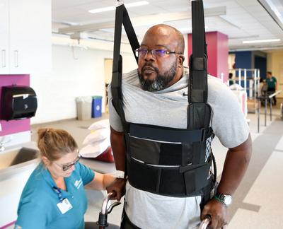 A patient walks with the aid of a Zero G assistance device during a session with a physical therapy rehabilitation specialist at MedStar Good Samaritan Hospital's inpatient rehab center.