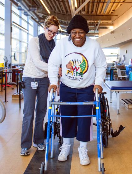 A MedStar Health physical therapist helps a patient with a walker in the MedStar National Rehabilitation Hospital inpatient rehabilitation program.