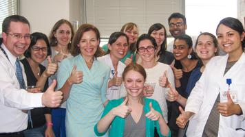 Graduates of MedStar Health's Internal Medicine and Pediatrics Residency program smile and give a "thumbs up."