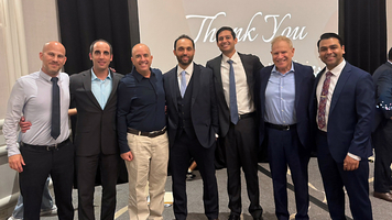 A team of MedStar interventional cardiology graduates stand pose for a class photo.