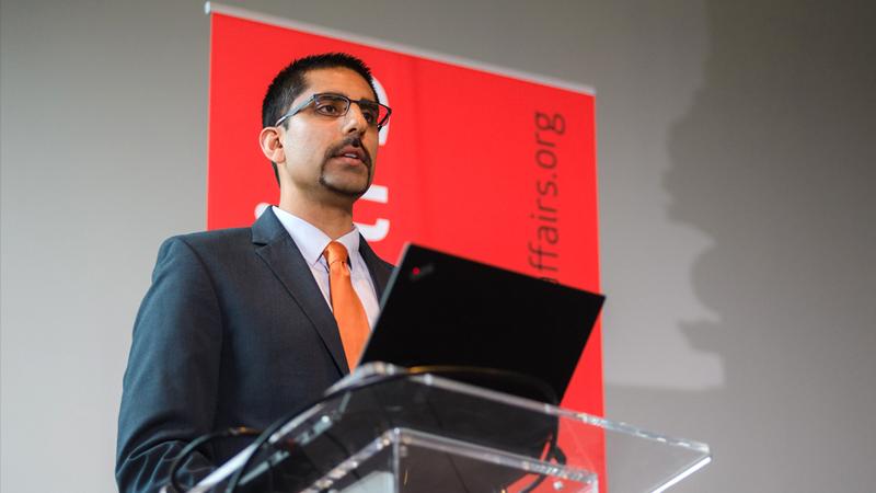 Raj Ratwani speaks from a podium at a professional conference.