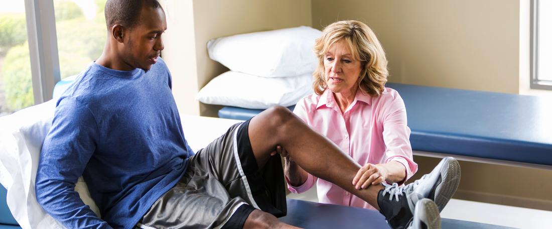 女性物理治疗提供者检查运动员受伤的膝盖
