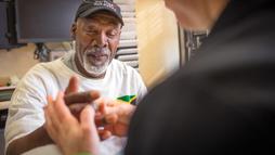 A patient works with a therapist as part of treatment for hand pain.