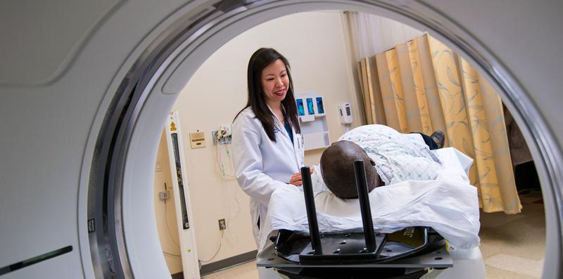 A doctor talks with a patient who is about to undergo diagnostic radiology.