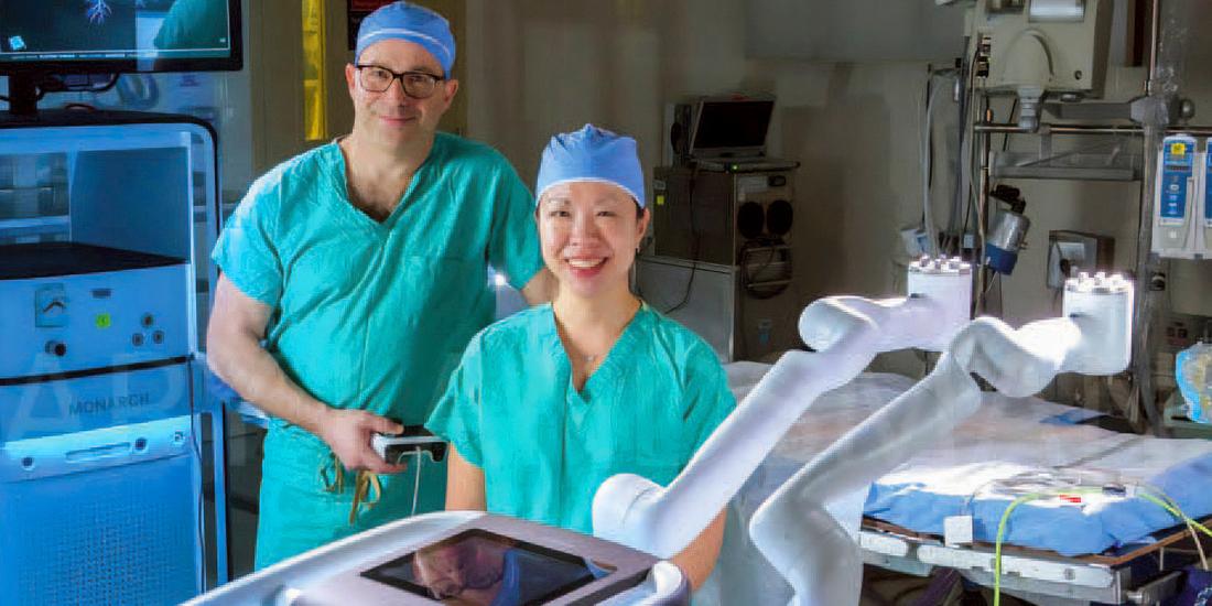 Doctors John Lazar and Jessica Wang Memoli stand and pose for a portrait in an operating room at MedStar Washington Hospital Center.