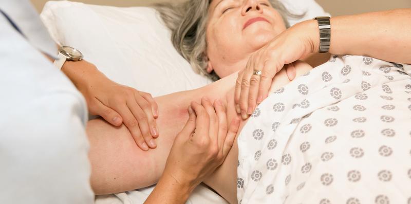 A therapist performs lymphedema therapy on a patient.