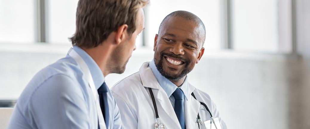 A doctor talks with a patient in a clincial setting.