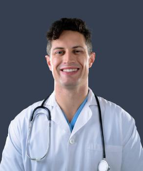 Portrait of a male healthcare provider wearing a white lab coat, with a stethoscope around his neck.