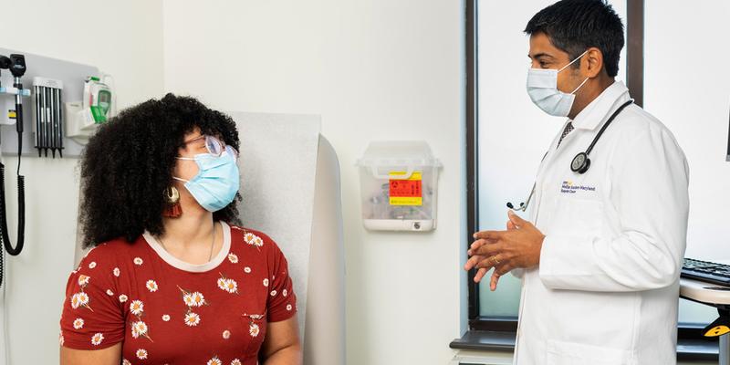 Dr Ankit Madan talks with a female patient during an office visit at MedStar Health.