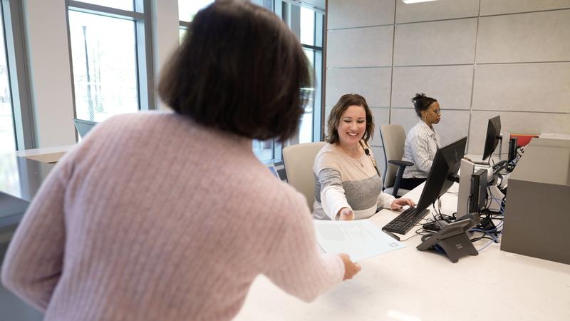 Associates help a patient at the front desk of the emergency department in the Verstandig Pavillion at MedStar University Georgetown Hospital.