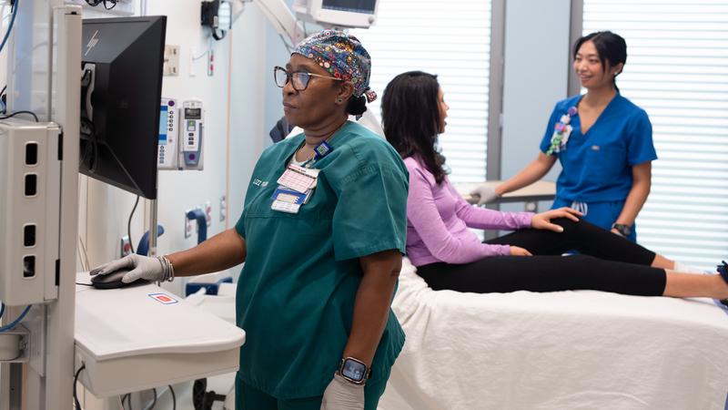 Nurses talk with a patient in a treatment room in the emergency department in the Verstandig Pavillion at MedStar University Georgetown Hospital.