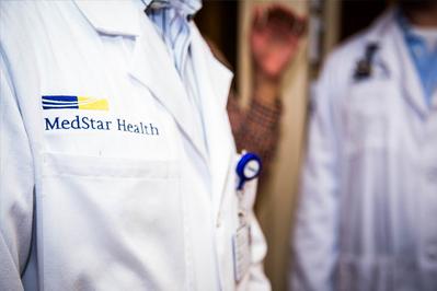 Closeup photo of the MedStar logo on a provider's white lab coat.